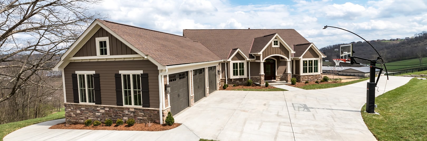 Exterior of home at The Reserve at Rivers Pointe with driveway and basketball hoop